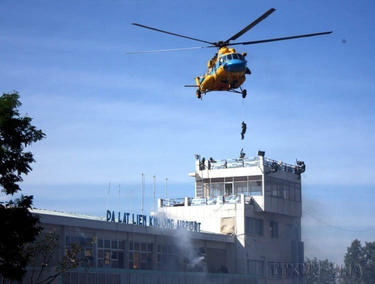 Fuerzas de policía de operaciones especiales simulan el uso de un helicóptero para infiltrarse en una torre de control y rescatar a un rehén, enfrentándose a actos ilegales que interfieren en la aviación civil, el 9 de diciembre de 2012 en el Aeropuerto de Lien Khuong (Lam Dong). (Foto: VNA)