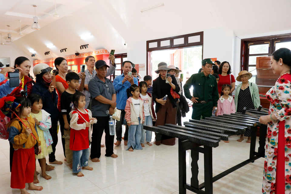 Visitantes disfrutando de una presentación de litófono en el espacio expositivo de Bom Bo. (Foto: VNA)
