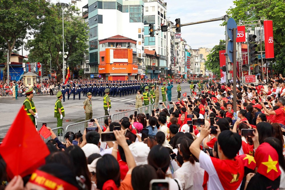 Las unidades del desfile y la procesión marchan por Cua Nam entre la cálida acogida del pueblo. (Foto: VNA)
