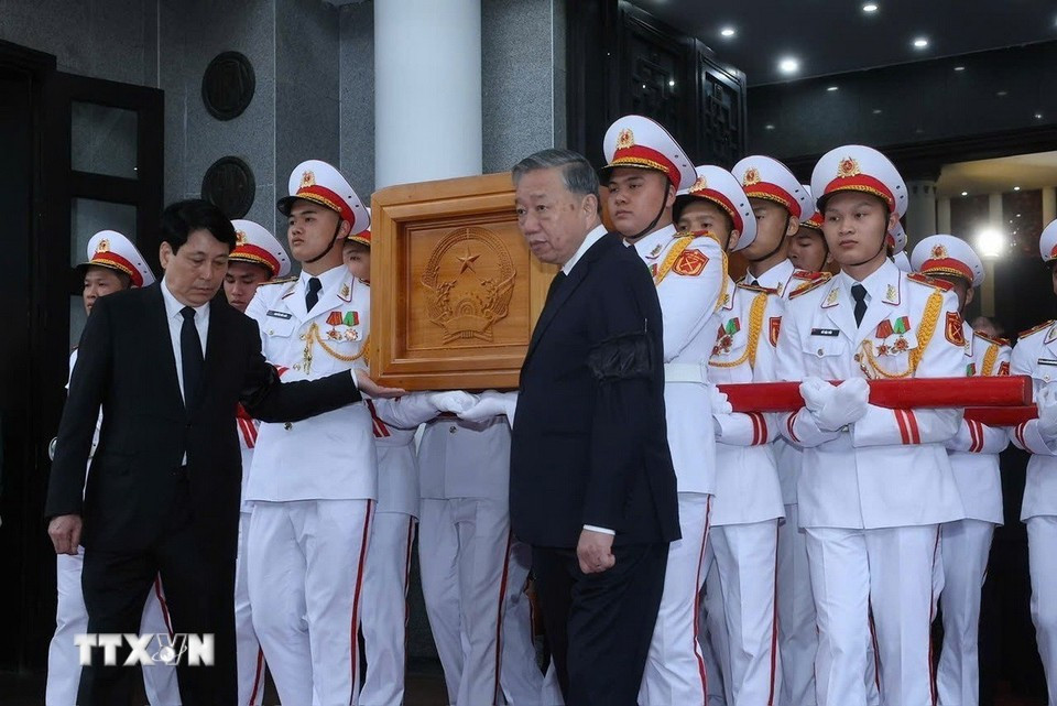 El secretario general To Lam y el presidente Luong Cuong trasladan el ataúd del expresidente Tran Duc Luong. (Foto: VNA)
