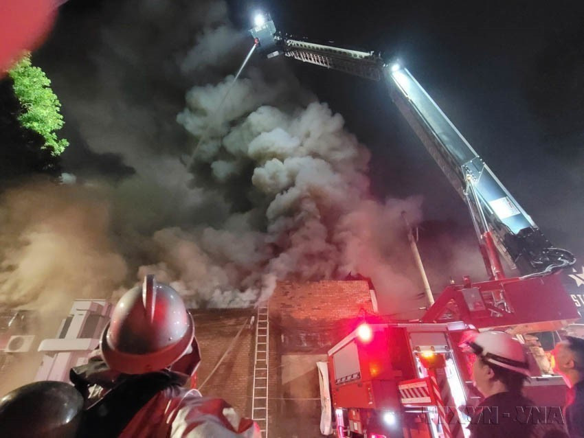 Fuerzas de bomberos utilizan equipo moderno para apagar un gran incendio en la calle Pho Duc Chinh (Hanoi). (Foto: VNA)