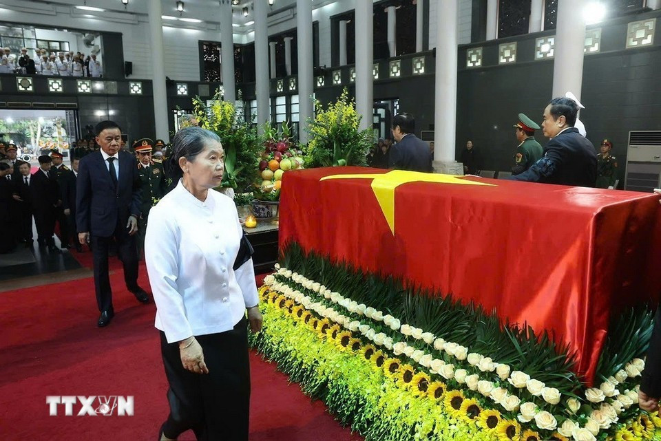 Men Sam An, vicepresidenta del Partido Popular de Camboya, presidenta del Consejo Nacional del Frente Unido para el Desarrollo de la Patria y de la Asociación de Amistad Camboya-Vietnam, rodea el ataúd en un emotivo adiós al expresidente Tran Duc Luong. (Foto: VNA)