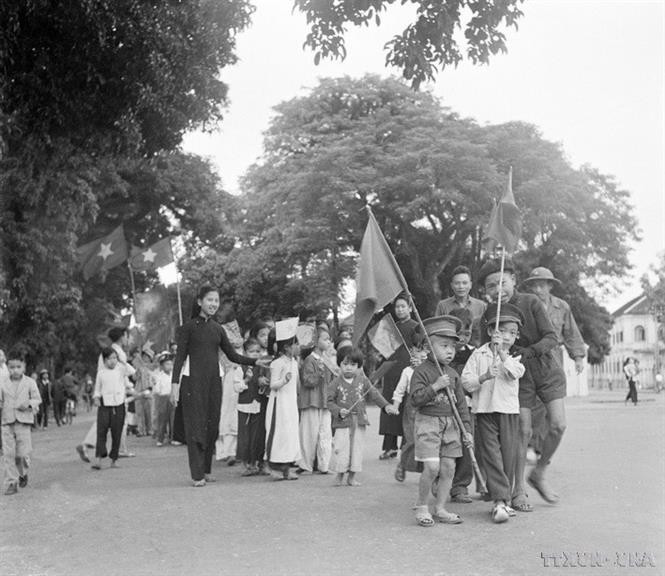 Niños y familias de Hanoi ondeaban banderas para dar la bienvenida a las tropas libertadoras. (Foto: Archivos de VNA)