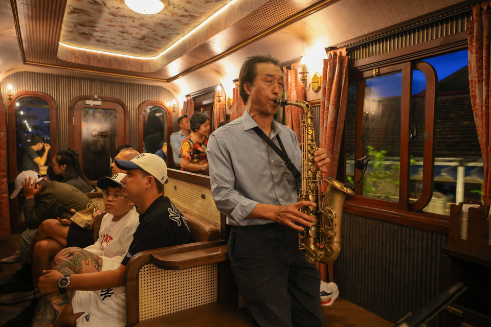 El saxofonista Phan Kim ameniza el ambiente con suaves melodías mientras el tren atraviesa paisajes poéticos con su interpretación de “Da Lat Hoang hon” (Atardecer en Da Lat). (Foto: VNA)