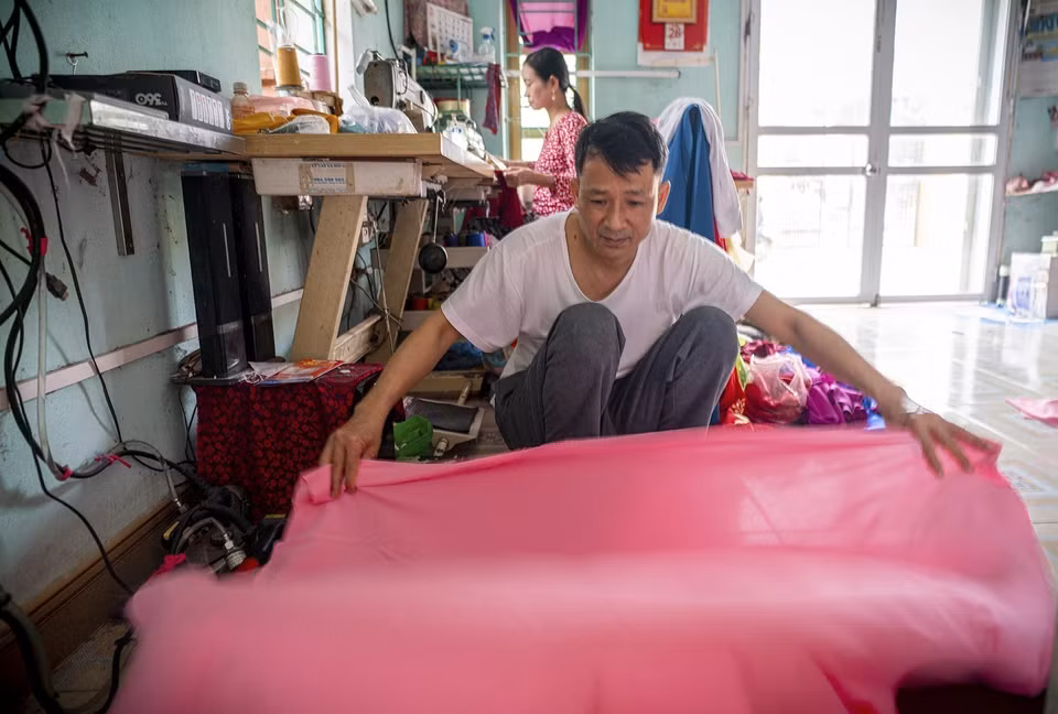 Otra razón por la que Trach Xa destaca es que no usa hilo industrial, sino hilos de seda extraídos de la misma tela para coser Ao dai. Así, la prenda queda uniforme, sin volverse rígida ni elástica al lavarla, y el dobladillo se mantiene siempre elegante y suave. (Foto: VNA)