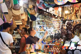 Turistas internacionales visitan y compran en el mercado de Ben Thanh. (Foto: VNA)