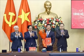 El primer ministro Pham Minh Chinh (segundo desde la izquierda) y el presidente de la Asamblea Nacional, Tran Thanh Man (extrema derecha), presentan la decisión del nombramiento y ofrecen flores a Nguyen Hong Dien. (Foto: VNA)