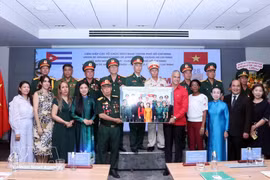Representantes del comité de enlace de veteranos del Batallón 261 - Giron en Ciudad Ho Chi Minh presentan una foto conmemorativa a Mauricio Alejandro Martínez Duque, Cónsul General de Cuba en la ciudad. (Foto: VNA)