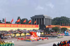Representantes de vietnamitas en el extranjero marchando por el escenario de la ceremonia. (Foto: VNA)
