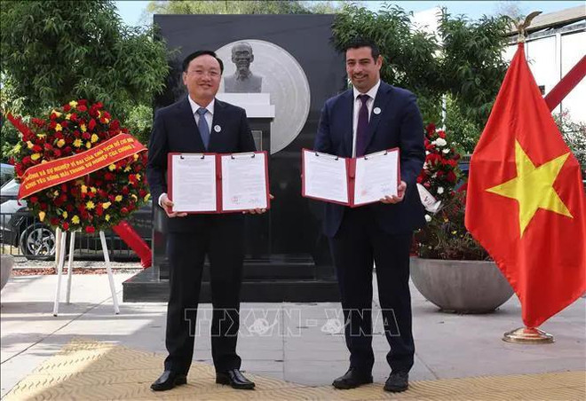Representantes del distrito de Nam Dan, provincia vietnamita de Nghe An, y la comuna de Cerro Navia entregan documentos de cooperación. (Fuente: VNA) hình_ảnh (1).webp