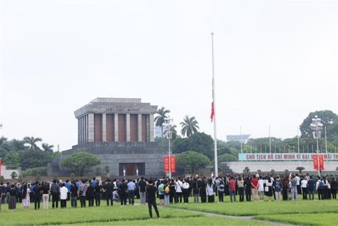 La ceremonia de izamiento de bandera nacional a media asta tuvo lugar a las 6:00 horas del 25 de julio en la plaza Ba Dinh. (Fuente: VNA) 2.jpg