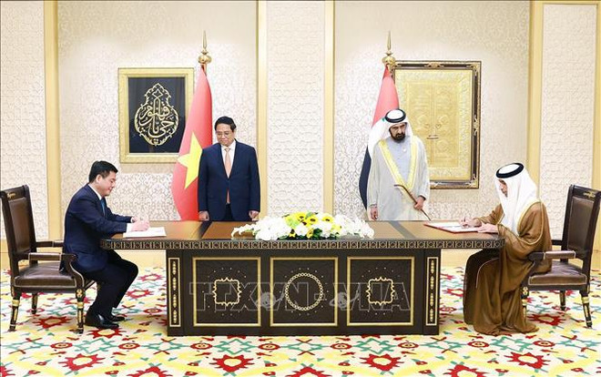 El primer ministro de Vietnam, Pham Minh Chinh, y el vicepresidente y primer ministro de los Emiratos Árabes Unidos (EAU), Sheikh Mohammed bin Rashid Al Maktoum, testimonian la firma del Acuerdo de Asociación Económica Integral. (Fuente: VNA) hình_ảnh.jpg