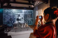 Los visitantes disfrutan de la exposición "La historia de la piedra preserva la memoria", que presenta un formato tradicional combinado con soluciones de tecnología digital (Foto: VNA)