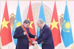 El presidente kazajo, Kassym-Jomart Tokayev (derecha), entrega la Orden de Dostyk de Primera Clase al secretario general del Partido Comunista de Vietnam, To Lam. (Foto: VNA)
