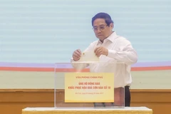 El primer ministro Pham Minh Chinh realiza una donación para ayudar a los pobladores a superar las consecuencias del tifón (Foto: VNA)