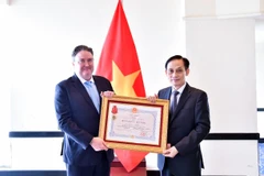 El ministro de Relaciones Exteriores, Le Hoai Trung (derecha), entrega la Orden de Amistad al embajador estadounidense Marc Evans Knapper (Foto: VNA)