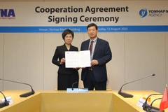 La directora general de la VNA, Vu Viet Trang, y el presidente de Yonhap, Hwang Dae-il, anuncian el acuerdo firmado entre ambas agencias (Foto: VNA)
