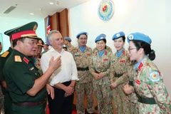 El viceministro vietnamita de Defensa, coronel general Hoang Xuan Chien, y el subsecretario de Defensa de Australia, Hugh Jeffrey, intercambian con las mujeres oficiales (Foto: VNA)