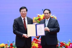 Qiu Yong (izquierda), secretario del Comité del Partido Comunista de China en la Universidad de Tsinghua, entrega el título de "Profesor Honorario" al primer ministro Pham Minh Chinh. (Foto: VNA)