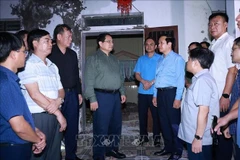 El primer ministro Pham Minh Chinh (centro) visita la comuna de Quy Nhat para inspeccionar y dirigir las labores de recuperación tras el tifón Bualoi. (Foto: VNA)