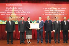 El embajador de Vietnam en Laos, Nguyen Minh Tam, entrega la Orden de la Independencia de primera clase a la Oficina presidencial de Laos. (Foto: VNA)