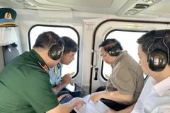 El primer ministro Pham Minh Chinh (segundo desde la derecha) realiza una inspección aérea desde un helicóptero de la autopista Ca Mau-Dat Mui, la carretera que conduce a Hon Khoai y el puerto de doble uso de Hon Khoai. (Foto: VNA) 