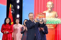 El secretario general del Partido Comunista de Vietnam, To Lam, recibe el libro de fotografías «La gloria pertenece por siempre al pueblo» de la VNA. (Foto: VNA)