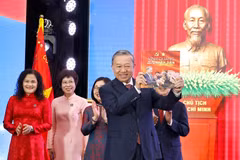 El secretario general del Partido Comunista de Vietnam, To Lam, recibe el libro de fotografías «La gloria pertenece por siempre al pueblo» de la VNA. (Foto: VNA)