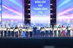 El primer ministro de Vietnam, Pham Minh Chinh, otorga certificados de mérito a colectivos e individuos con logros destacados en la organización de la exposición (Foto: VNA)