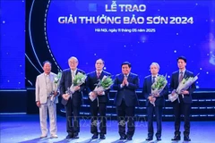 El viceprimer ministro Nguyen Chi Dung entrega flores para felicitar a los ganadores. (Foto: VNA)