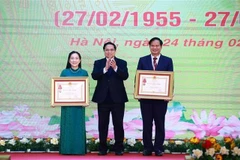 El primer ministro de Vietnam, Pham Minh Chinh, otorga las Órdenes de Trabajo de Tercera Clase a Dao Xuan Co, director del Hospital Bach Mai, y Nguyen Thi Mai Ngoc, doctora del Instituto Cardiovascular del nosocomio. (Foto: VNA)