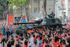 Los pobladores saludan a las formaciones de tanques y vehículos blindados. (Foto: VNA)