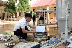 El maestro Hoang Huu Duong, director de la escuela secundaria de la comuna de Yen Binh, en la provincia de Lang Son, revisa los materiales didácticos para determinar cuáles aún se pueden utilizar y procurará aprovecharlos al máximo. (Foto: VNA)