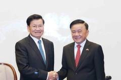 El miembro del Buró Político y miembro permanente del Secretariado del Comité Central del Partido, Tran Cam Tu (derecha), y el secretario general del Partido Popular Revolucionario de Laos y presidente del país, Thongloun Sisoulith (Foto: VNA)