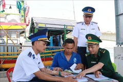 Las autoridades pertinentes movilizan a los pescadores a firmar un compromiso para combatir la pesca ilegal en el puerto pesquero de Cua Viet. (Foto: VNA)