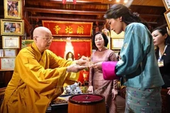 El muy venerable Thich Thanh Nha entrega a la reina butanesa Jetsun Pema Wangchuck y Nguyen Thi Minh Nguyet, esposa del presidente vietnamita, hojas de Bodhi elaboradas artesanalmente. (Foto: VNA)