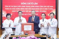 El secretario general del Partido Comunista de Vietnam, To Lam, regala un obsequio a funcionarios y personal médico del Hospital de la Amistad. (Foto: VNA)