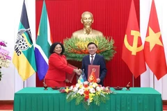 El miembro del Buró Político y permanente del Secretariado del Comité Central del PCV, Tran Cam Tu, y la vicesecretaria general del ANC de Sudáfrica, Nomvula Mokonyane, intercambian un documento de cooperación entre los dos Partidos (Foto: VNA)