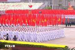 La formación con la bandera del Partido y la bandera nacional (Foto: VNA)