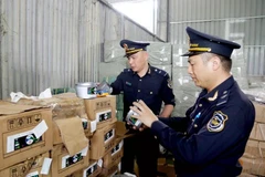 Agentes de aduanas del puesto fronterizo internacional de Huu Nghi (provincia de Lang Son) revisan las etiquetas de las mercancías importadas (Foto: VNA)
