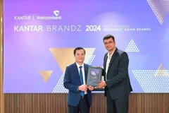 Le Hoang Tung, subdirector general de Vietcombank (izquierda), recibe el certificado de Sumit Kamra, director de desarrollo estratégico de Kantar Insights. (Foto: VNA)