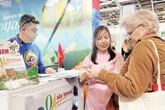 Turistas franceses estudian sobre destinos vietnamitas en la 49ª Feria Mundial de Turismo celebrada en París (Foto: VNA).
