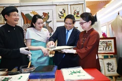 El primer ministro de Vietnam, Pham Minh Chinh, y su homóloga tailandesa, Paetongtarn Shinawatra, contemplan productos artesanales vietnamitas únicos (Foto: VNA)