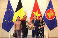 El embajador de Laos en Bélgica, Kingphokeo Phommahaxay (izquierda), entrega flores al embajador de Vietnam en el país europeo, Nguyen Van Thao. (Foto: VNA)