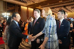 El presidente del Comité Popular de Ciudad Ho Chi Minh, Nguyen Van Duoc, felicita al embajador de Estados Unidos en Vietnam, Marc E. Knapper, y a la cónsul general de ese país en la urbe, Susan Burns, en la ceremonia. (Foto: VNA)