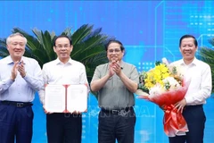 El primer ministro vietnamita, Pham Minh Chinh (segundo desde la derecha), entrega a las autoridades locales la decisión que aprueba la planificación de Ciudad Ho Chi Minh. (Foto: VNA)