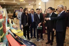 Los delegados visitan una exposición en el foro. (Foto: VNA)