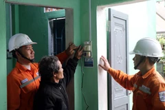 El personal eléctrico instruye a los residentes sobre el uso de equipos eléctricos al mudarse a sus nuevos hogares. (Foto: VNA)