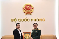 El jefe del Estado Mayor General del Ejército Popular de Vietnam y viceministro de Defensa, general Nguyen Tan Cuong, entrega un obsequio al coronel general Saichay Kommasith, viceministro de Defensa y jefe del Estado Mayor General del Ejército Popular de Laos. (Foto: qdnd.vn)