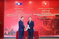 El secretario del Comité Central del PCV y jefe de su Oficina, Le Hoai Trung (derecha), y su similar del PPRL, Thongsalith Mangnomek (Foto: VNA)